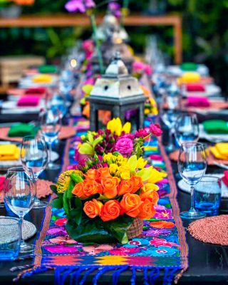 Montaje de mesa mexicana decorada con flores y colores típicos mexicanos