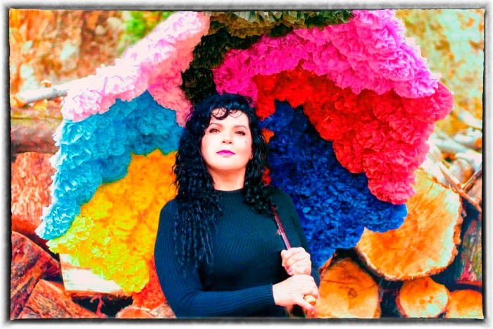 foto de Francis González sosteniendo una sombrilla de flores de colores